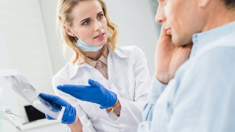 man-consulting-with-dentist-looking-at-x-ray-in-modern-clinic.jpg